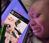 a man is crying while looking at a picture of a woman holding a knife