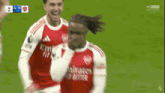 a group of soccer players are celebrating a goal on a soccer field .