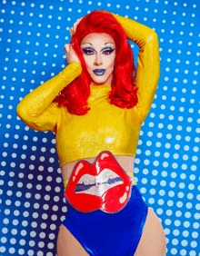 a woman with red hair wearing a yellow top and blue shorts