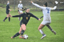 two women are playing soccer on a field and one of them is wearing a mask .