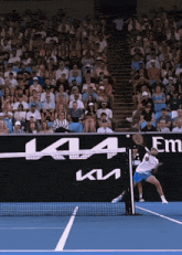 a tennis player is swinging a tennis racket in front of a sign that says kt4