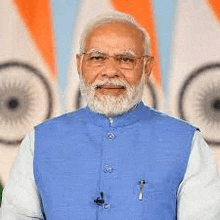 the prime minister of india is wearing a blue vest and glasses .