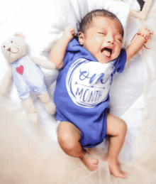 a baby wearing a blue shirt that says one month on it