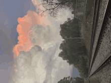 a train track with a cloudy sky and a rainbow in the background