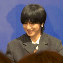 a man wearing a suit and tie is smiling