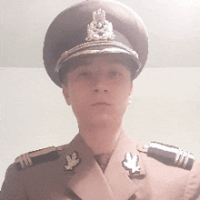 a man in a military uniform with a hat and badges on his shoulder