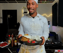 a man in an apron holds a plate of food