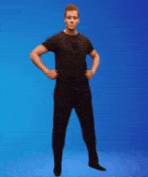 a man in a black shirt and black pants is dancing on a blue background .