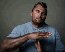a man wearing a blue shirt is clapping his hands
