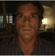 a man in a striped shirt is looking at the camera