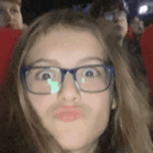 a girl wearing glasses is making a funny face with her mouth open