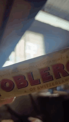 a person is holding a toblerone swiss milk chocolate bar