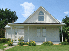 a white house with a porch and a window on the front