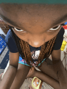 a little girl sitting on a bed with a jar of vaseline on her lap