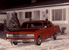 a red car is parked in front of a brick house