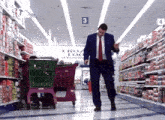 a man in a suit and tie is walking through a grocery store aisle with the number 3 on the ceiling above him