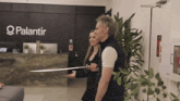 a man and a woman are standing in front of a palantir sign
