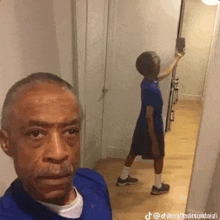 a man is taking a selfie with a boy in front of a mirror .