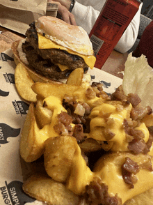 a hamburger and french fries are on a paper that says simply burger