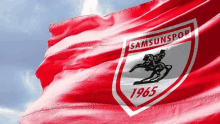 a red flag with a logo for samsunspor 1965 on it