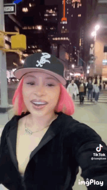 a woman with pink hair is taking a selfie on a street .