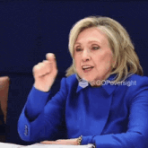 a woman wearing a blue jacket has a sticker on her jacket that says gopoversight