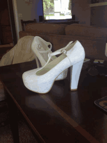 a pair of white shoes sit on a table in front of a couch