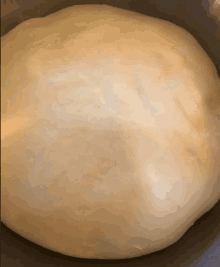 a large ball of dough is sitting in a metal bowl