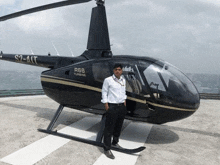 a man stands in front of a helicopter that says r66 turbine on it