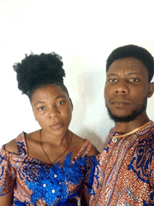 a man and a woman are posing for a picture and the woman is wearing a blue top