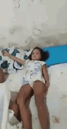 a little girl is laying on top of a bed .