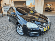 a black volkswagen car is parked on a brick pavement