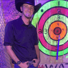 a man wearing a cowboy hat stands in front of a target with the number 4 in the middle