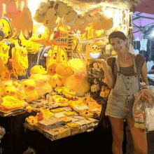 a woman stands in front of a display of stuffed animals with a sign that says 200 sale on it