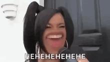 a woman with pigtails is laughing into a microphone while wearing hoop earrings .