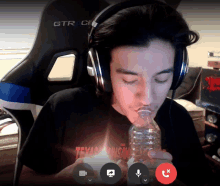 a man wearing headphones and a shirt that says texas insane is smoking a bottle of water