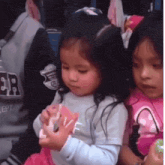 two little girls are sitting next to each other and one is wearing a shirt that says ' ept ' on it