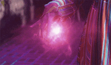 a close up of a person 's hand holding a purple object