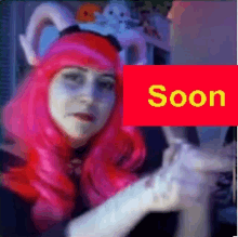 a woman with pink hair and a red sign that says " soon "