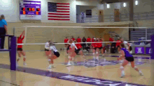 a volleyball game is being played in a gym with a scoreboard behind the net that shows the score of 16 to 3