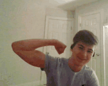 a young man is flexing his muscles in a room