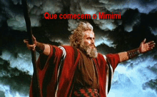 a man in a red robe holding a cane with the words que comecem o mimimi written above him