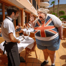 a man wearing a british flag t-shirt talks to a waiter