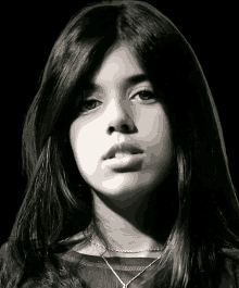 a black and white photo of a girl with long hair and a necklace