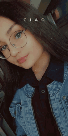 a girl wearing glasses and a denim jacket has the word ciao on her face