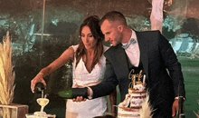 a bride and groom are cutting their wedding cake and pouring champagne