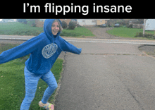 a girl wearing a blue hoodie that says lacrosse is flipping a ball