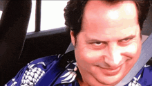 a man wearing a blue shirt with a pineapple on it is smiling