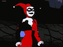 harley quinn from the batman animated series is holding a knife in her hand and smiling .