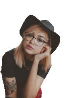 a woman wearing glasses and a hat is sitting down